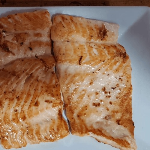Pescado dorado servido en plato blanco
