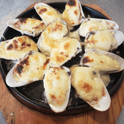 Machas a la parmesana servidas en sus conchas