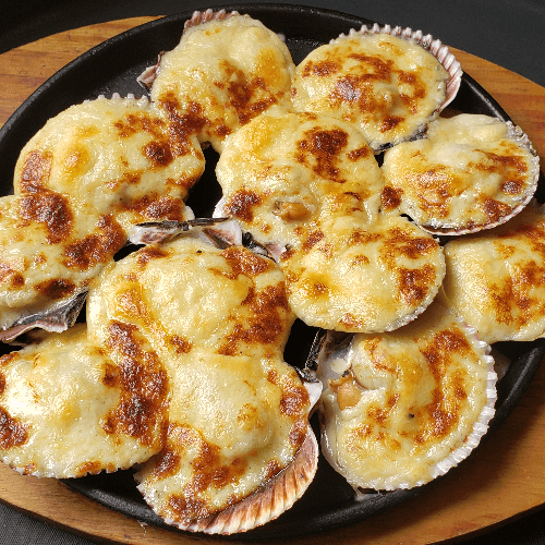 Ostiones a la parmesana servidos en conchas